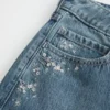 Baggy-Jeans mit niedriger Leibhöhe, dunkler Waschung und Blumenstickerei Baggy-Jeans mit niedriger Leibhöhe, dunkler Waschung und Blumenstickerei