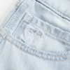 Baggy-Jort mit niedriger Leibhöhe, heller Waschung und Schleifenverzierung Baggy-Jort mit niedriger Leibhöhe, heller Waschung und Schleifenverzierung