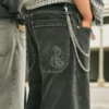 Gewaschene schwarze Baggy-Jeans mit Schlangenstickerei Gewaschene schwarze Baggy-Jeans mit Schlangenstickerei