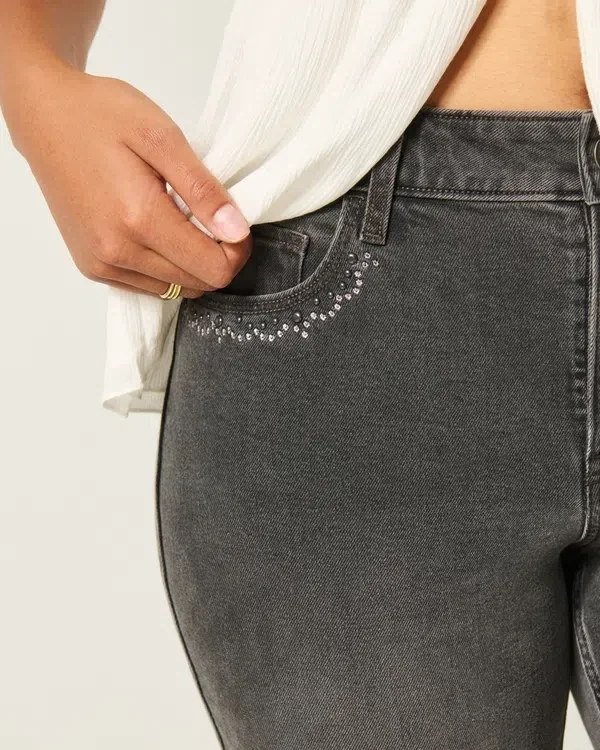 Hoch geschnittene, gewaschene schwarze Jeans mit Stickerei und ausgestelltem Bein Hoch geschnittene, gewaschene schwarze Jeans mit Stickerei und ausgestelltem Bein