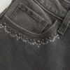 Hoch geschnittene, gewaschene schwarze Jeans mit Stickerei und ausgestelltem Bein Hoch geschnittene, gewaschene schwarze Jeans mit Stickerei und ausgestelltem Bein
