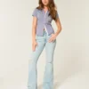 Hoch geschnittene, leicht verwaschene Flare-Jeans mit Rissen Hoch geschnittene, leicht verwaschene Flare-Jeans mit Rissen