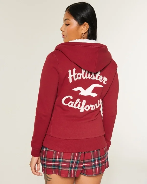 Holiday Vault Release Sherpa-gefütterter Hoodie mit Reißverschluss und Logo-Grafik Holiday Vault Release Sherpa-gefütterter Hoodie mit Reißverschluss und Logo-Grafik