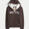 Holiday Vault Release Sherpa-gefütterter Hoodie mit Reißverschluss und Logo-Grafik Holiday Vault Release Sherpa-gefütterter Hoodie mit Reißverschluss und Logo-Grafik