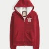 Holiday Vault Release Sherpa-gefütterter Hoodie mit Reißverschluss und Logo-Grafik Holiday Vault Release Sherpa-gefütterter Hoodie mit Reißverschluss und Logo-Grafik