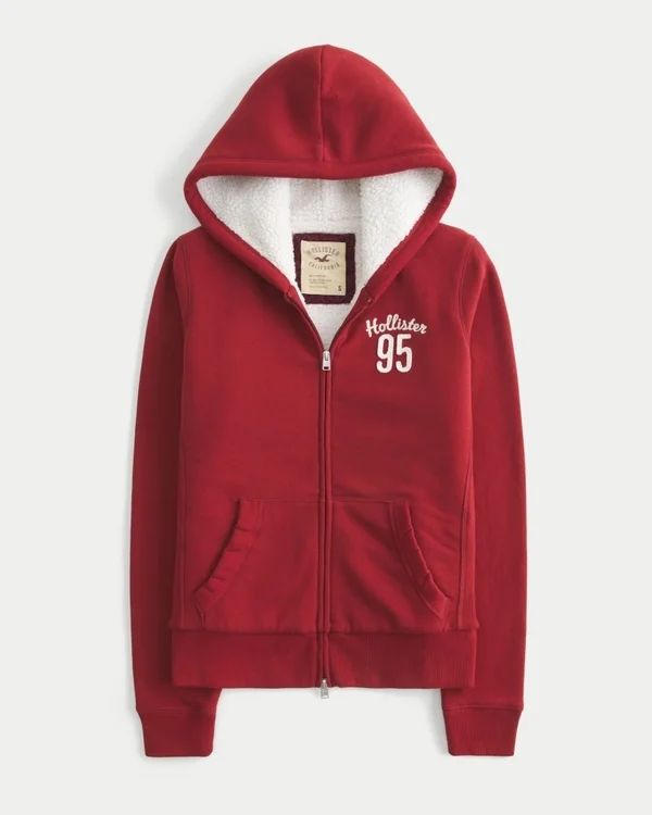 Holiday Vault Release Sherpa-gefütterter Hoodie mit Reißverschluss und Logo-Grafik Holiday Vault Release Sherpa-gefütterter Hoodie mit Reißverschluss und Logo-Grafik