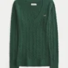 Ikonischer Pullover mit V-Ausschnitt und Zopfmuster Ikonischer Pullover mit V-Ausschnitt und Zopfmuster