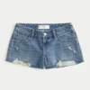 Mini-Shorts aus mittelblauem Denim mit niedriger Leibhöhe und Used-Look Mini-Shorts aus mittelblauem Denim mit niedriger Leibhöhe und Used-Look