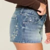 Ultra Low-Rise Mini-Shorts aus mittelblauem Denim mit Blumenstickerei Ultra Low-Rise Mini-Shorts aus mittelblauem Denim mit Blumenstickerei