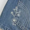 Ultra Low-Rise Mini-Shorts aus mittelblauem Denim mit Blumenstickerei Ultra Low-Rise Mini-Shorts aus mittelblauem Denim mit Blumenstickerei
