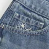 Ultra Low-Rise Mini-Shorts aus mittelblauem Denim mit Blumenstickerei Ultra Low-Rise Mini-Shorts aus mittelblauem Denim mit Blumenstickerei